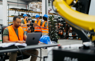 Naklejka premium Engineers collaborating on innovative robotics project in modern factory