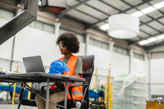 Young african american female engineer working on laptop in factory