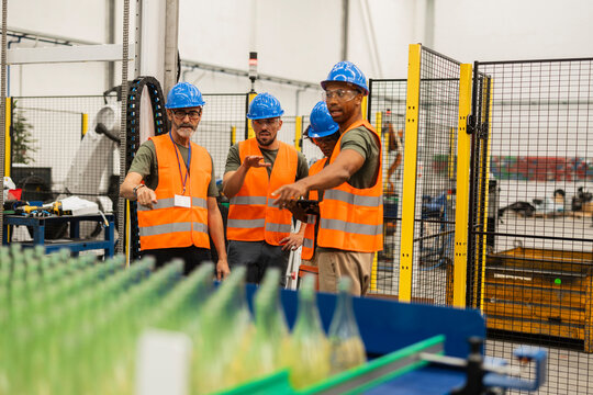 Engineers supervising production line in bottling factory