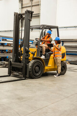 Engineers working together managing forklift in factory © PintoArt