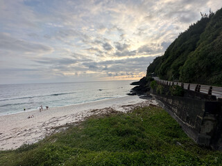 Scenic Beach with Lush Greenery and Dramatic Sky
