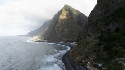 Scenic Coastal Road Beneath Majestic Cliffs and Clouds