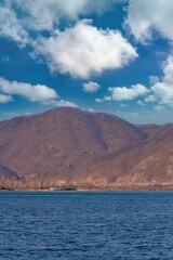 View of lake and mountain with cloudy blue sky