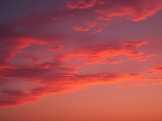 Fototapeta premium Vivid orange and pink hues of a setting sun against a deep blue evening sky, colorful, evening