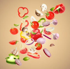 Naklejka premium Many different fresh vegetables in air on light brown background