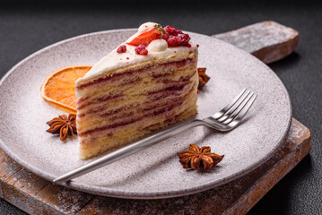 Piece of sweet layer cake with white cream, raspberries and strawberries