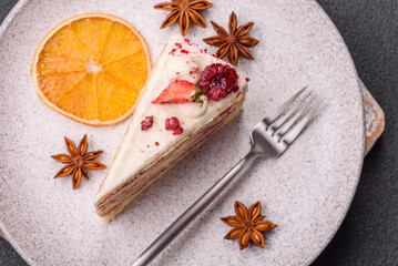 Piece of sweet layer cake with white cream, raspberries and strawberries