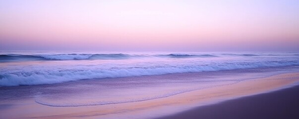 Obraz premium Serene beach at sunset with gentle waves and pastel sky hues.
