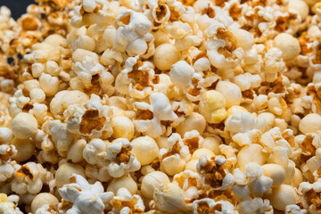 A detailed shot of a bowl of fluffy, crispy popcorn with golden buttery kernels, perfect for enjoying during movie nights or as a satisfying snack.