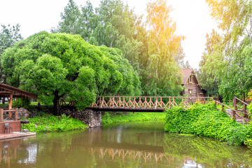 a water channel and traditional half-timbered houses. The river is surrounded by greenery and a beautiful suspension.