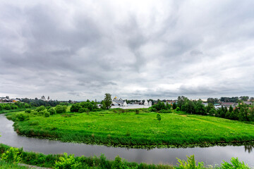Suzdal, Russia, Golden Ring: Pokrovsky white stone monastery in summer against the background of the Kamenka River.