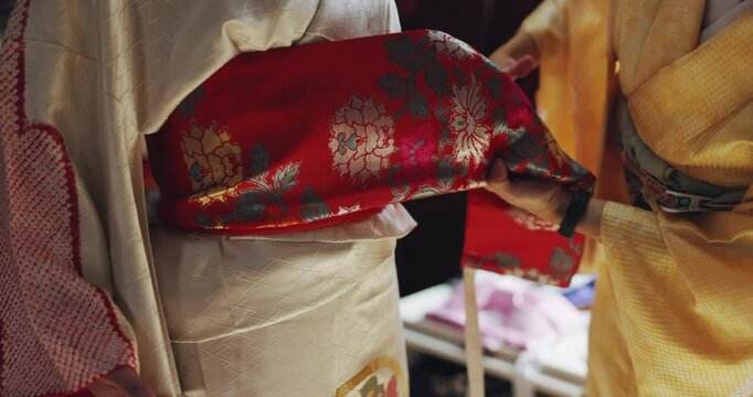 Hands, fashion designer and client with kimono dress for fitting and traditional event in Japan. Seamstress, customer and people with fabric or clothes at workshop with creativity, textiles and style