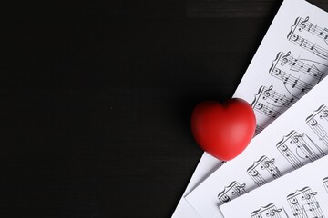 Heart figure and musical notes on black wooden background, top view. Space for text
