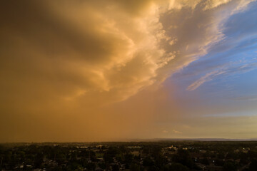 A cloudy sky with a bright orange sun in the background