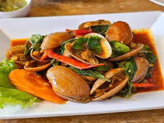 Stir-fried clams dish thai cuisine food photography restaurant setting close-up view culinary delight