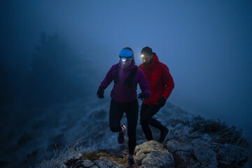 Night trail runner of men and women running on the mountain.at night milky way © .shock