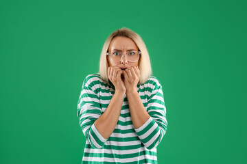 Portrait of scared woman on green background