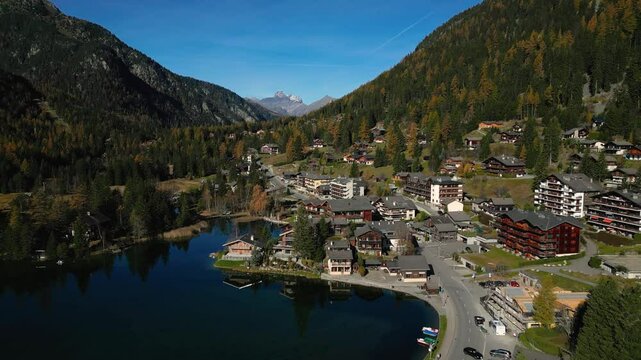 Amazing aerial autumn drone footage of mountains, lake and village at Champex-Lac in the Swiss Alps in the Canton of Valais