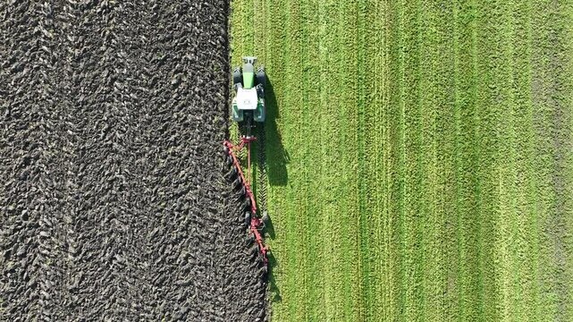 Vue d'avion d'un tracteur en train de labourer un champ &agrave; l'automne, avec une herse pour pr&eacute;parer le champ aux futurs semis. Agriculture intensive