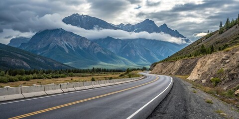 Fototapeta premium Empty highway asphalt road winding through a mountain pass with peaks in the background, asphalt, road