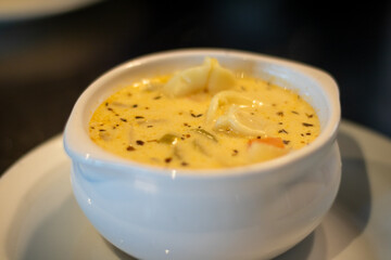Creamy yellow soup in a white ceramic bowl.