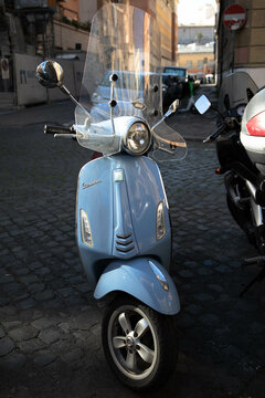 a light blue Vespa parked on teh street in Rome, Italy