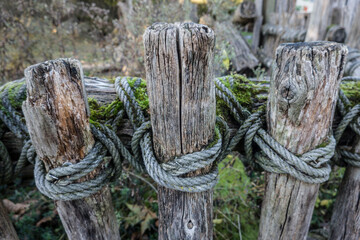 rustikaler Zaun aus Holzlatten und einem Seil