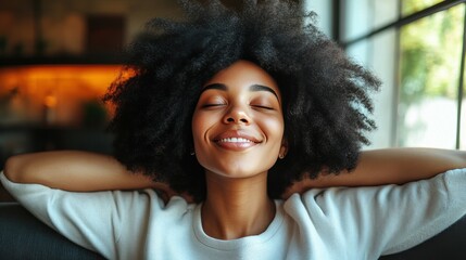 Fototapeta premium A young woman sits comfortably on a couch, smiling with her eyes closed, enjoying a serene moment at home filled with sunlight and warmth, radiating happiness and relaxation