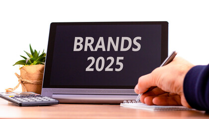 Planning brands 2025 new year symbol. Concept words Brands 2025 on beautiful black tablet. Beautiful white background. Businessman hand. Business brands 2025 new year concept. Copy space.