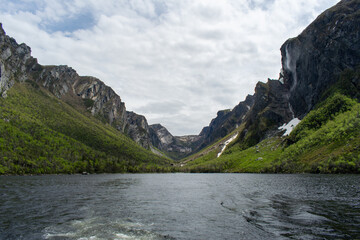 At the eastern end of Western Brook Pond, where the fjord meets, the serene waters and majestic cliffs highlight the breathtaking beauty of Gros Morne National Park.