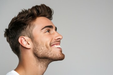 Fototapeta premium Young man smiling during cosmetology procedure isolated on grey.