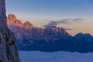 Obraz premium Mountains above the clouds stunning landscape. High rocky peaks rising through mist, this scene captures dramatic high-altitude views with soft cloud cover and rugged terrain in Dolomiti Alps