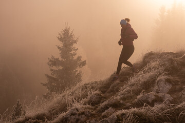 trail running woman athlete training for ultra-marathon race in a mountain