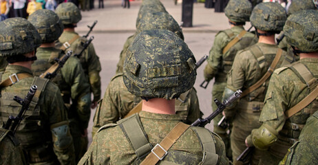 Russian soldiers in camouflage uniforms and helmets marching in a military parade