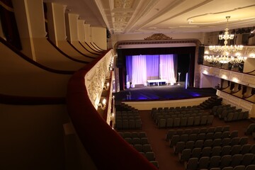 Theatre interior with stage, rows of comfortable seats and beautiful chandelier