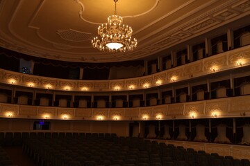 Rows of comfortable seats and beautiful chandelier in theatre