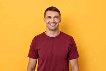 Obraz premium Smiling man with dental braces on yellow background