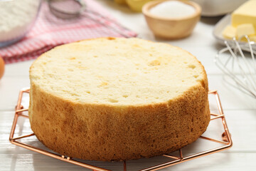 Tasty cut sponge cake on white wooden table