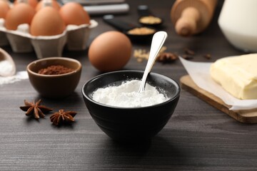 Baking powder and other products on grey wooden table, closeup