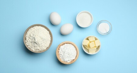 Baking powder and other ingredients for making dough on light blue background, flat lay