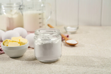 Baking powder and other ingredients for making dough on table, space for text
