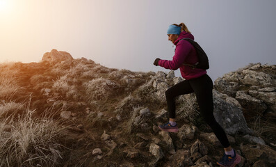 trail running woman athlete training for ultra-marathon race in a mountain