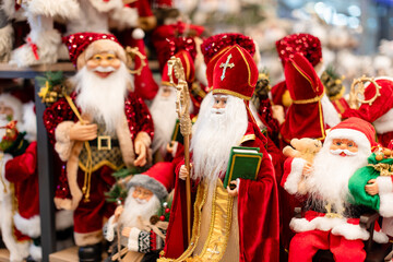 Vibrant collection of Saint Nicholas and Santa Claus figurines in elaborate red and gold costumes,...
