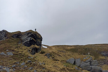 Fototapeta premium A man standing on a stone in the middle of the wild nature of Mageroya Island, Norway