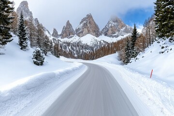 A snowy road with a mountain range in the background