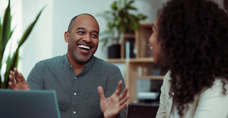 Smiling business professionals engaging in a collaborative discussion during a casual office meeting, fostering teamwork and communication