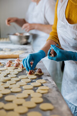 Making homemade dumplings, placing meat filling on dough circles in a busy kitchen environment