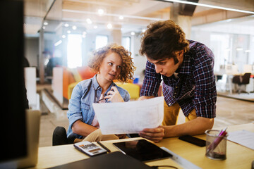 Two young colleagues working on a project together in the office