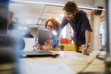 Two young colleagues working on a project together in the office
