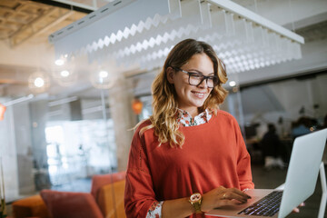 Young woman using a laptop while working in the office